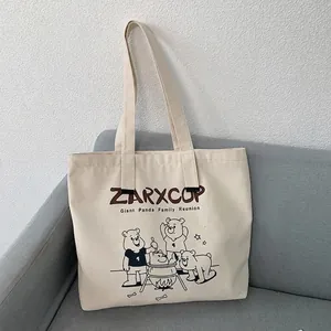 Detail of panda cartoon print and typography on minimalist off-white canvas tote bag