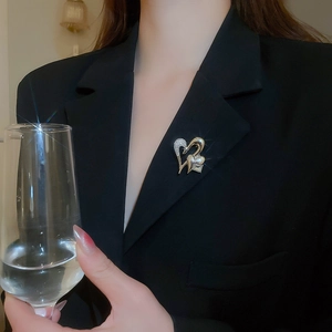 Close-up of sparkling intertwined heart brooch with zircons on a black blazer lapel