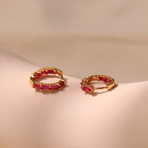 Close-up of 18K gold plated hoop earrings with channel-set red rectangular zircons