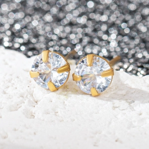 Détail macro de boucles d'oreilles plaquées or 18k avec zircons ronds étincelants