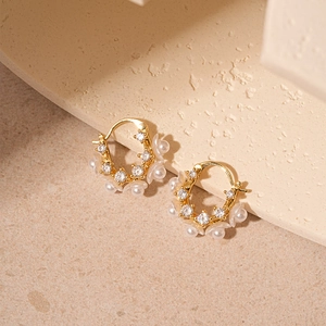 Eleganti orecchini a cerchio dorati con fiori, zirconi e perle su base in pietra