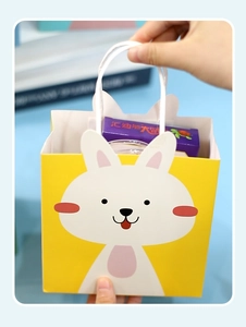 Vue détaillée du sac cadeau lapin jaune avec poignée blanche montrant sa grande capacité