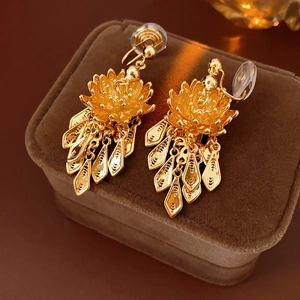 Detailed macro view of gold-plated lotus fringe ear clip on premium velvet box
