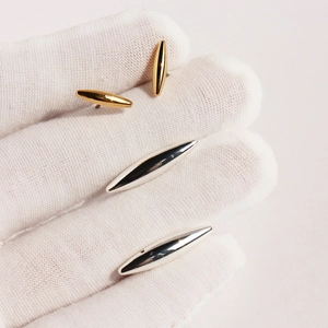 Fashionable two-tone silver and gold stud earrings in geometric oval rivet shape for women