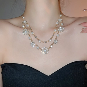 Close-up of double-layer necklace with sunflower pearl charms and pavé crystals