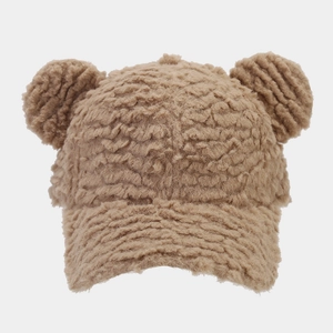 Detail of light brown plush baseball cap with cute bear ears and curly lamb wool texture