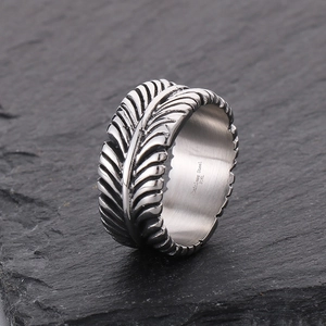 Detailed close-up of 316L stainless steel feather ring with vintage textured engraving