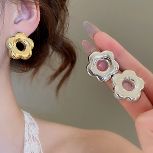 Vue détaillée de boucles d'oreilles fleurs et nœuds en or et argent sur un mannequin