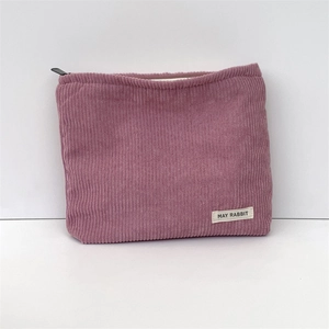 Pink corduroy makeup bag detail showing texture, zipper, and May Rabbit label