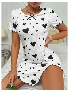 Détail d'une robe d'intérieur blanche côtelée avec motifs cœurs noirs et bords ondulés
