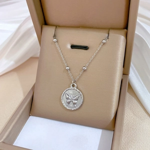 Minimalist silver titanium steel necklace with a butterfly coin pendant in a jewelry box
