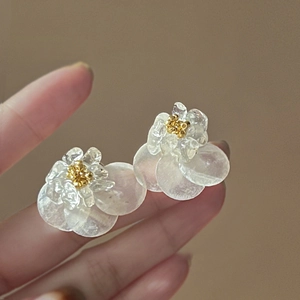 Gros plan de boucles d'oreilles fleurs avec pétales en nacre et centre doré