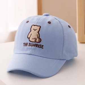 Close-up of embroidered bear and THI SUNRISE text on kids sky blue cotton baseball cap