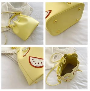 Detailed views of yellow fruit bucket bag with citrus patches and metal bottom studs