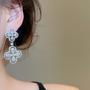 Macro detail of silver floral stud earrings with sparkling white cubic zirconia stones