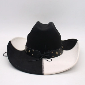 Detail of western cowboy hat with black and white patchwork and studded leather band