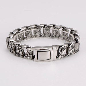 Detail of vintage embossed patterns on silver stainless steel chain bracelet for men