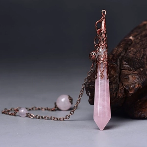 Macro shot of rose quartz pendulum with vintage copper hollow pattern and crystal beads