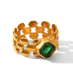 Détail de la bague bracelet de montre dorée avec pierre précieuse carrée verte émeraude