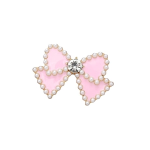 Pink bow decoration with white pearls and a sparkling center diamond on white background