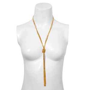 Detail einer goldenen mehrsträngigen Schlangenkette mit Knotendesign und langen Quasten