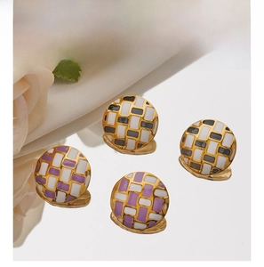 Detail showing checkered enamel mosaic stud earrings with polished gold finish