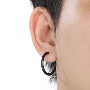 Close-up of minimalist black titanium steel round hoop earring worn on the earlobe