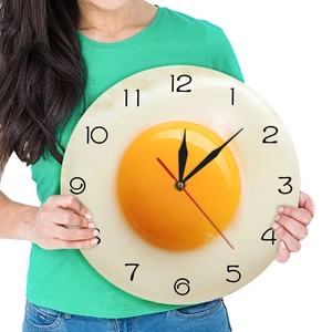 Creative fried egg wall clock held by model showing large scale and minimalist 3D design
