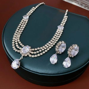 Close-up of sparkling cubic zirconia teardrop necklace and earrings set in green gift box