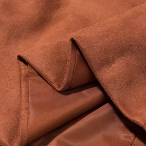 Close-up of caramel suede fabric with smooth lining showing premium texture and stitching