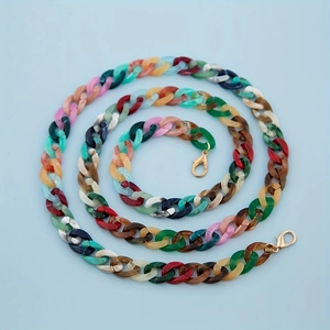 Detail van kleurrijke acryl schakelketting met gouden karabijnsluitingen voor tassen