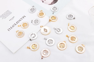 Flat lay of multiple stainless steel pendants with hollow tree and shell inlay details
