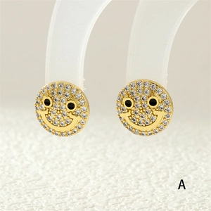 Macro shot of 18K gold plated smiley earrings with white zircon and black enamel details