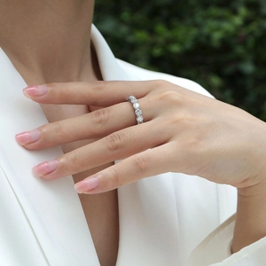Detailed view of a 925 sterling silver moissanite eternity ring on a model's finger