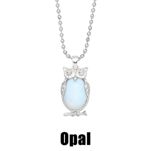 Macro view of owl pendant featuring a light blue oval opal stone in silver setting