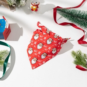 Close-up of red Christmas pet bandana featuring Santa Claus print and Ho! Ho! lettering
