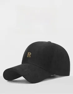 Detail shot of a black textured baseball cap featuring a premium golden metallic R logo