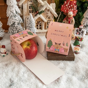 Pink Christmas apple gift boxes with reindeer cartoons and Merry Christmas text in snow