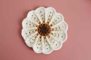 Detailed view of handmade gradient sunflower coaster with layered crochet wool petals