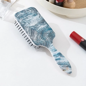 Detail view of air cushion hairbrush featuring blue and white wave pattern print