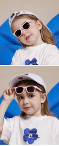 Pink toddler sunglasses shown on a child model with a stylish summer outfit