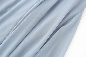 Details des graublauen Netzstoffs und der Faltenstruktur am ärmellosen Maxikleid