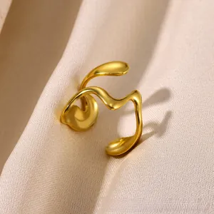 Detailed view of wave-shaped gold ring on luxury champagne silk fabric background