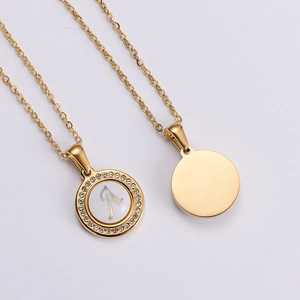 Detail of round gold pendant necklace with rhinestones and engraved letter A