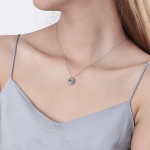Elegant silver crown pendant necklace with sparkling rhinestones worn on a female neck