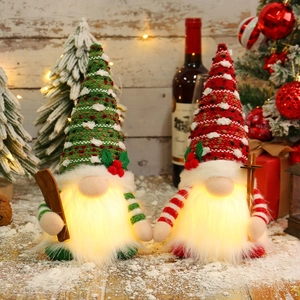 Lighted Christmas gnomes with sequins and LED lights on a snowy wooden table