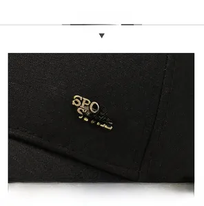 Detail of black baseball cap with bronze metal plate featuring sports style text