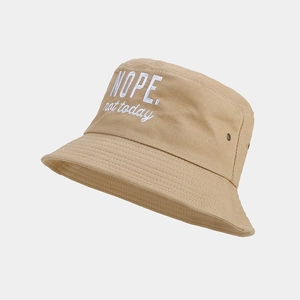 Detail of cotton bucket hat featuring white letter embroidery and metal ventilation eyelets