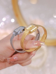 Close-up of luxury gold and silver square watches with crystal bezels and mesh bands