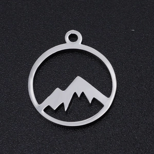 Macro view of a circular stainless steel mountain peak pendant with a polished silver finish